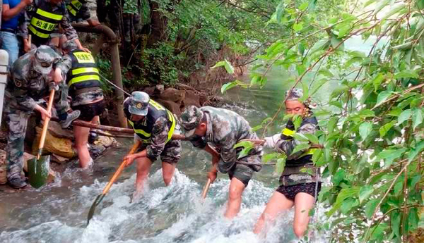 面對諾日朗瀑布再次坍塌的險情 民兵突擊隊跳入水中疏通河道